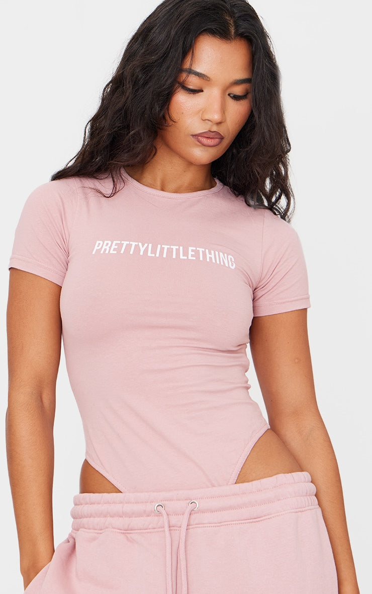 https://cdn-img.prettylittlething.com/1/7/2/6/172651ccbd87cce7c191facce5397f8020621fb0_CNF2379_4_prettylittlething_light_pink_logo_short_sleeve_bodysuit.jpg